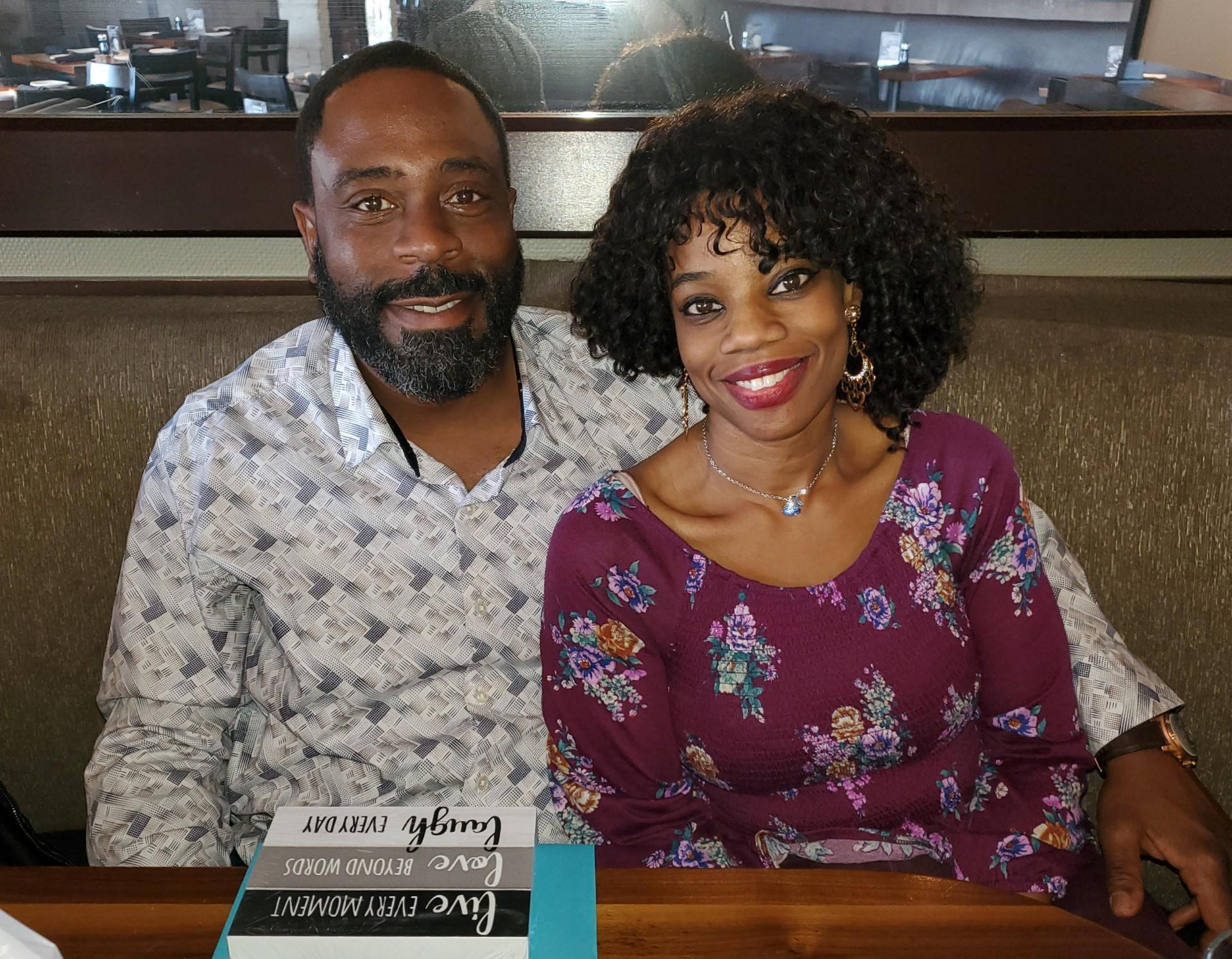 Nyla and Jeff sitting together and smiling at the camera.