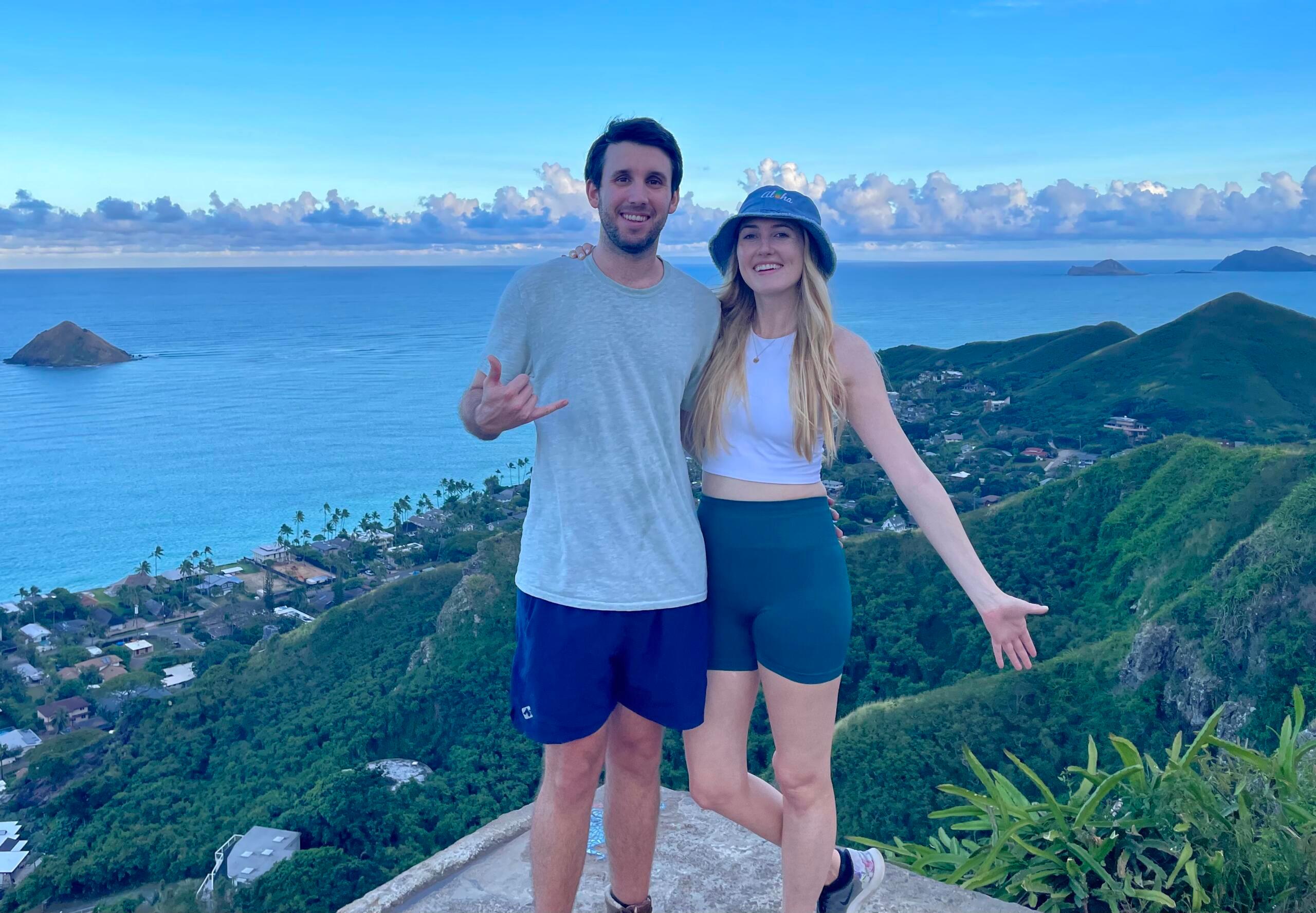 Jose and Katie standing in front of a seascape and smiling.